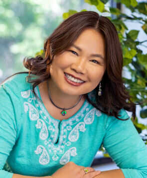 Therapist Huiling Pritchett's professional headshot wearing a teal top outdoors