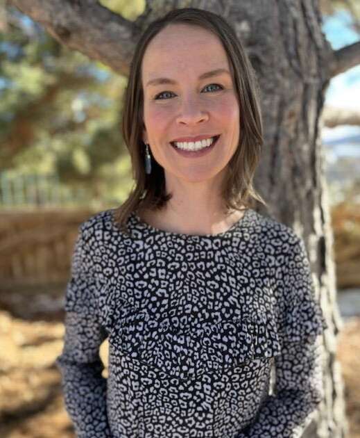 Kaiser therapist, Roberta Robinson is in a blouse and standing in front of a tree in Denver.